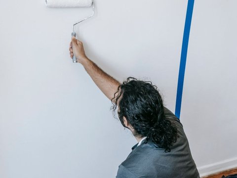 Painter rolling a wall