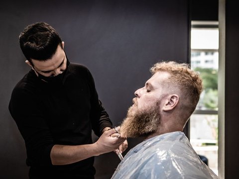 Barber trimming a beard
