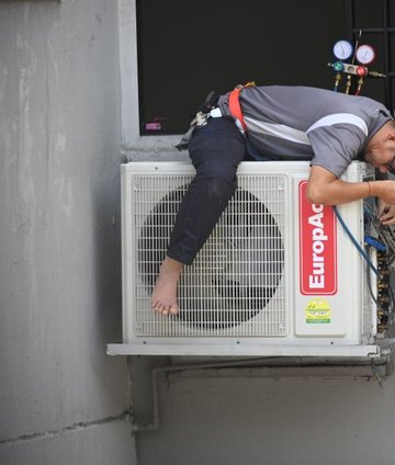 Technician servicing an outdoor AC unit